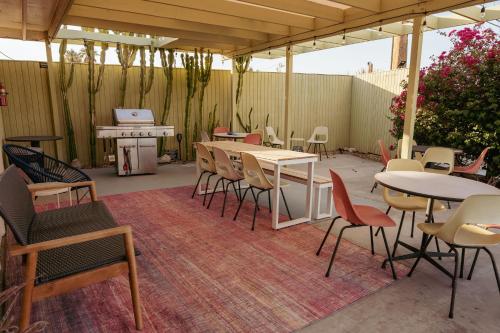 a patio with tables and chairs and a piano at Hope Springs Resort in Desert Hot Springs