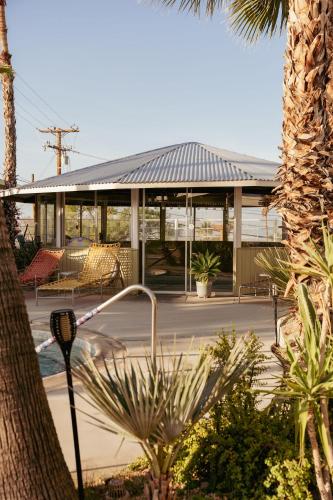 a building with a conservatory with tables and chairs at Hope Springs Resort in Desert Hot Springs