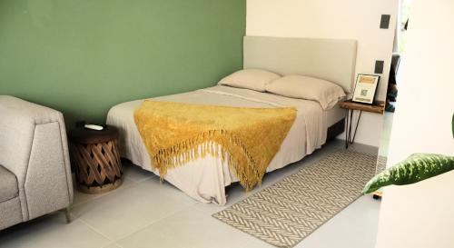 a bedroom with a bed with a yellow blanket on it at Chan Studio Tulum in Tulum