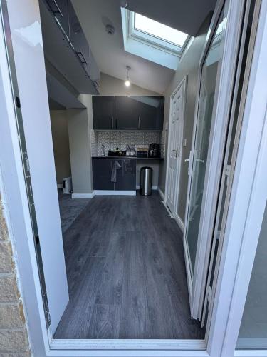 an empty room with a kitchen and a hallway at Private Studio Retreat with WiFi & HD TV & Workspace in Huddersfield