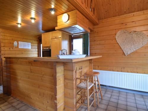 a kitchen with a bar in a log cabin at Comfortable Chalet in Ovifat near Ski Lift in Waimes