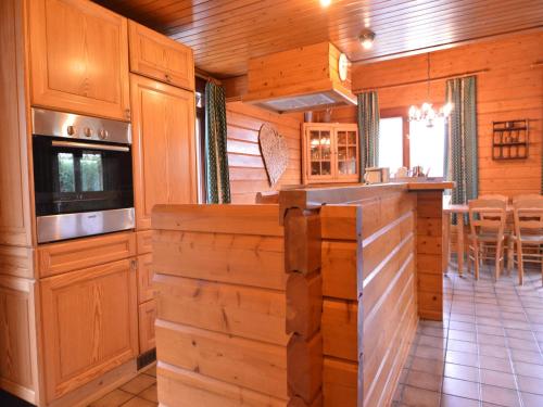 a kitchen with wooden cabinets and a counter in a cabin at Comfortable Chalet in Ovifat near Ski Lift in Waimes