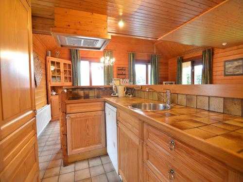 a large kitchen with wooden cabinets and a sink at Comfortable Chalet in Ovifat near Ski Lift in Waimes