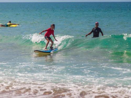 un jeune enfant chevauchant une vague sur une planche de surf dans l'océan dans l'établissement Nice apartment in French Basque Country, à Ondres