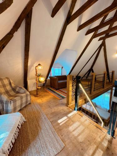 a attic room with a bed and a staircase at Inside, The Village- The Brick Loft in Tunari