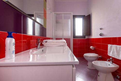 a bathroom with a white sink and a toilet at B&B Solesun in Trapani