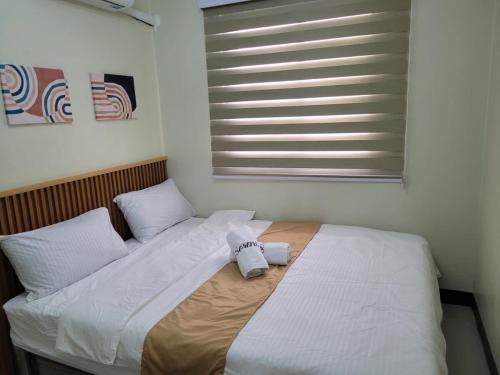 a bedroom with two beds with white sheets and a window at Serenity 3 New cozy Home in Balintiouac