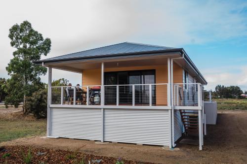 a house with a balcony with people standing on it at Long Island Retreat - Rosella in Murray Bridge