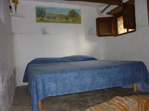 a bedroom with a bed with a blue blanket on it at La Casa di Gilda in Gizzeria