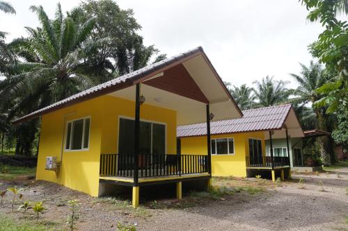 a small yellow house with a metal roof at Khao Sok Palmview Resort in Khao Sok