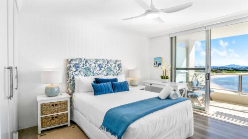 a bedroom with a bed and a large window at Beachpoint 402 in Forster