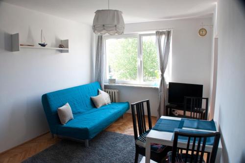 un soggiorno con divano blu e tavolo di Morski Sen a Danzica