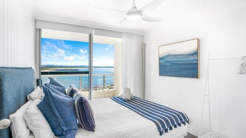ein Schlafzimmer mit einem Bett mit Blick auf das Meer in der Unterkunft Beachpoint 402 in Forster