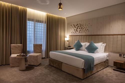 a hotel room with a large bed and a chair at الضيافة المثالية للشقق المخدومة Aldiyafa Serviced Apartments in Jeddah