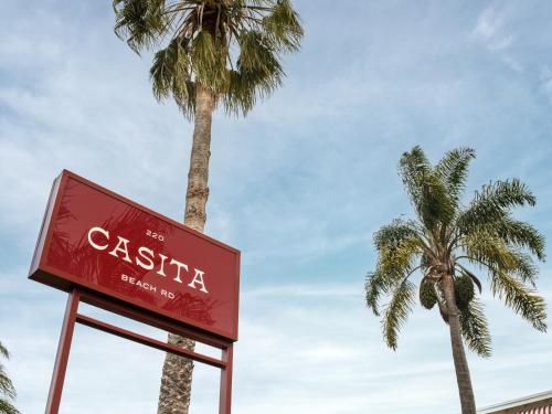a sign in front of two palm trees at The Isla & Casita in Batemans Bay