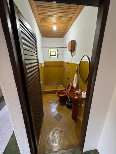 a bathroom with a toilet and a mirror at Pousada Recanto Das Gerais in Carmo do Rio Claro