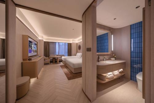 a hotel room with a bed and a bathroom at Orange Crystal Beijing Capital Airport New International Exhibition Hotel in Beijing