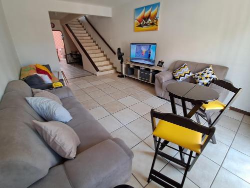 a living room with a couch and a television at Pontal Hostel Suite Ilhéus in Ilhéus