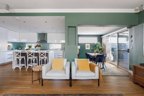 a kitchen and living room with two chairs and a table at Marina Blue - Bold Bayside Charm by the Foreshore in Williamstown