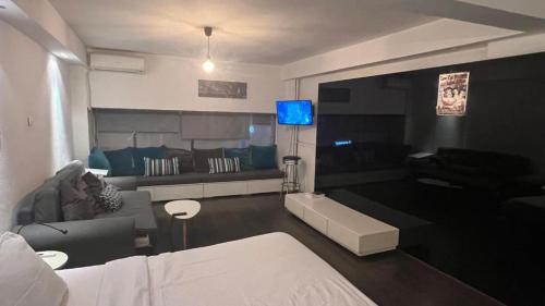 a living room with a bed and a couch at Loft for 4 to the center of Thessaloniki in Thessaloniki