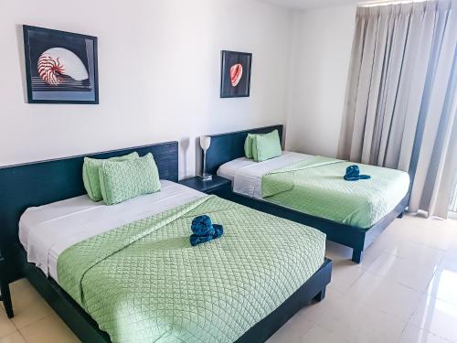 two beds in a room with blue flowers on them at Golden Sun Penthouse VIP in Playa Blanca