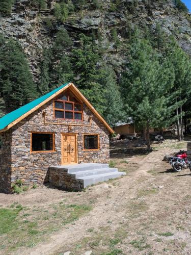 a small stone building with a blue roof at Shepherd's Lore Camps & Resort in Sāngla