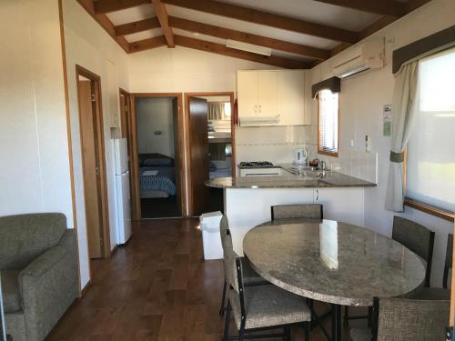 a kitchen with a table and chairs in a room at Golden Terrace Holiday Park in Lakes Entrance