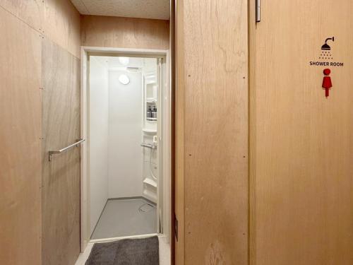 a door to a room with an open refrigerator at 石垣ゲストハウスオハナ in Ishigaki Island
