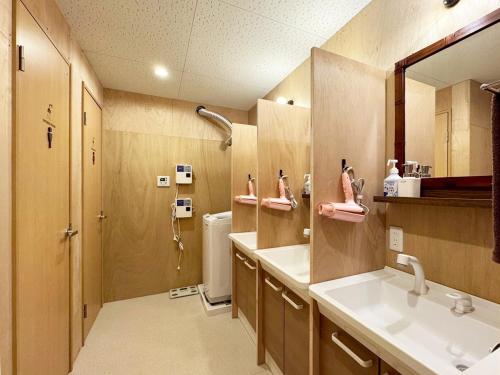 a bathroom with a sink and a shower at 石垣ゲストハウスオハナ in Ishigaki Island