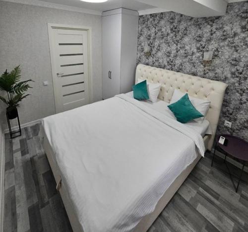 a large white bed with green pillows in a bedroom at Escapada romantica cu jacuzzi in Chisinau in Chişinău