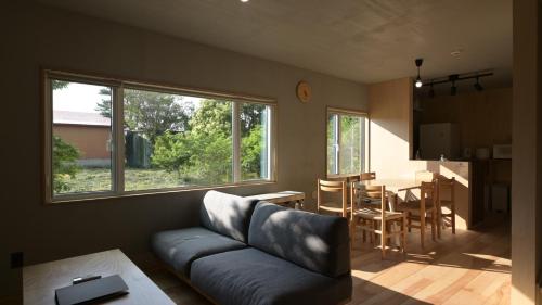a living room with a couch and a table at Good Wood House Higashikawa in Higashikawa