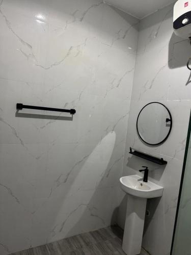 a white bathroom with a sink and a mirror at Sohana Homes in Ikeja