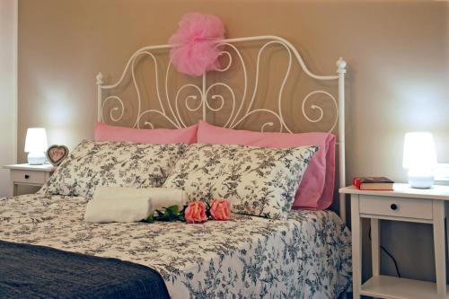 a bed with a pink headboard and flowers on it at Villa Milu in Quinto di Treviso