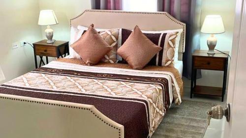 a bedroom with a bed with pillows and two night stands at Chic 2BDR Oceanview Escape, Pool & Beach Access in Discovery Bay