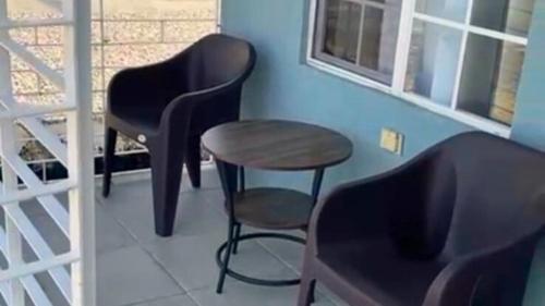 a room with two chairs and a table and a stool at Chic 2BDR Oceanview Escape, Pool & Beach Access in Discovery Bay