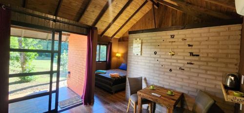 a living room with a table and a bedroom at El Pueblito Lodge in El Soberbio