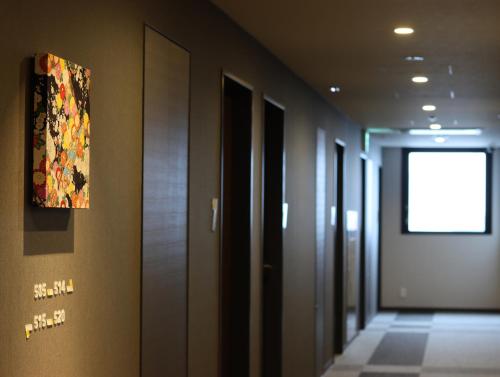 a hallway of a building with a painting on the wall at Wander Kyoto Nanajo in Kyoto