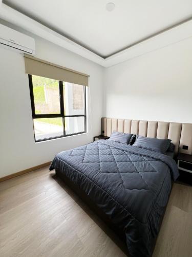 a bedroom with a bed and a window at Moment Villa in Lembang