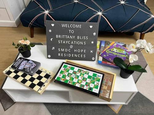 a table with a chessboard and a sign on it at Brittany Bliss Staycations at SMDC HOPE RESIDENCES in Trece Martires
