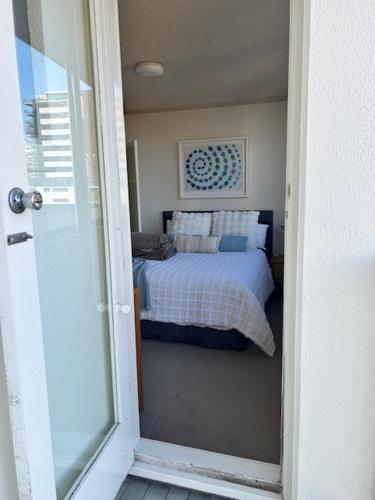 a bedroom with a bed and a view of a door at Beachfront Oceanic 5 in Forster