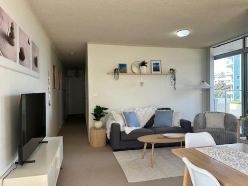 a living room with a couch and a table at Beachfront Oceanic 5 in Forster
