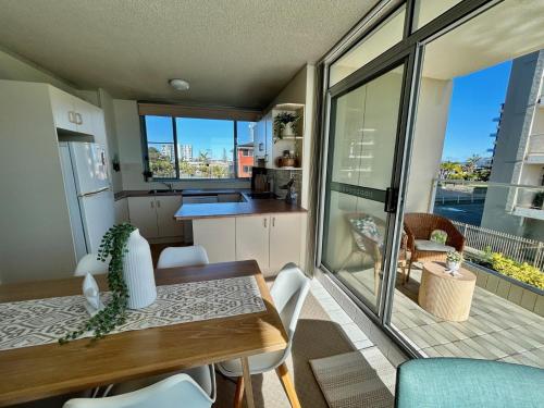 a kitchen and dining room with a table and chairs at Beachfront Oceanic 5 in Forster