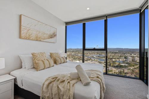 a bedroom with a white bed and large windows at Modern 1 Bedroom Unit at The Casino - NO PARKING - Q Stay in Gold Coast