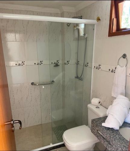 a bathroom with a glass shower with a toilet at Pousada Pedacinho do Céu in Conservatória