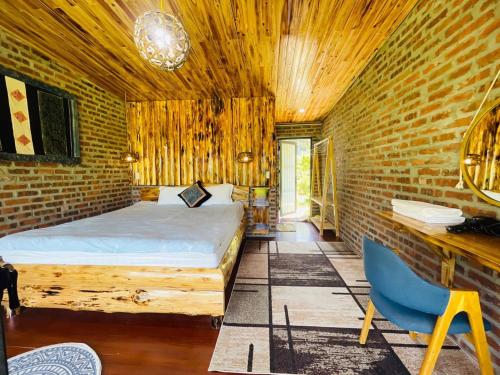 a bedroom with a bed and a brick wall at lúa Cafe Eco Lodge in Sapa
