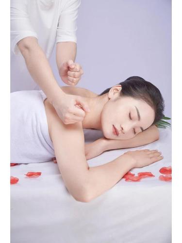福州市にあるVienna Hotel Fuzhou Mawei Banzheng Cultural Scenic Area Branchの男性がベッドの上で女性をマッサージしている