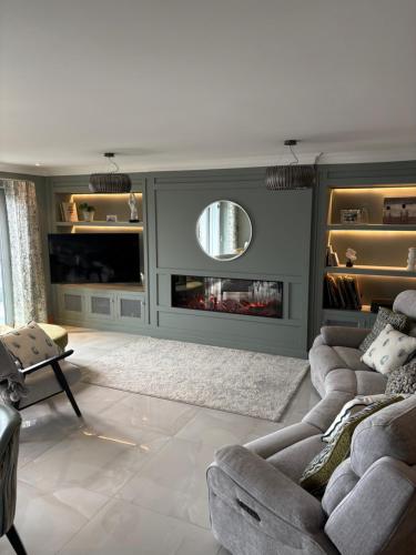 a living room with two couches and a fireplace at Prime Port Apartment in Portstewart