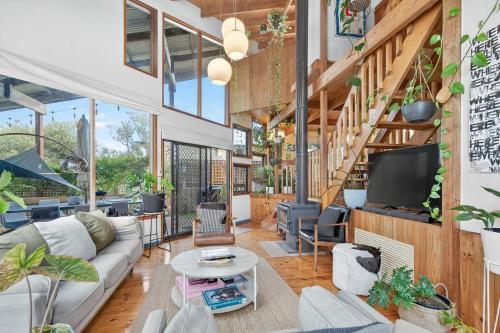 a living room with a couch and a tv at CHALET MOMA Port Elliot - BYO Linen - for lovers of different in Port Elliot