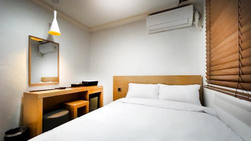 a hotel room with a bed and a mirror at Restia Stay in Seoul