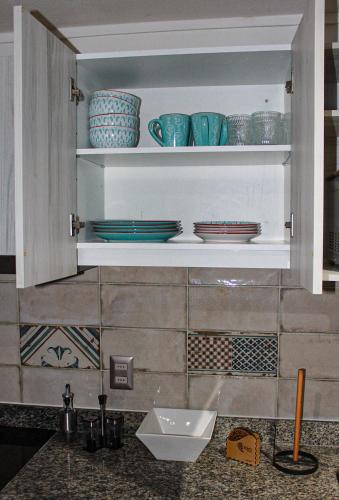 a kitchen cabinet with plates and bowls in it at Auroras apartment in Santiago
